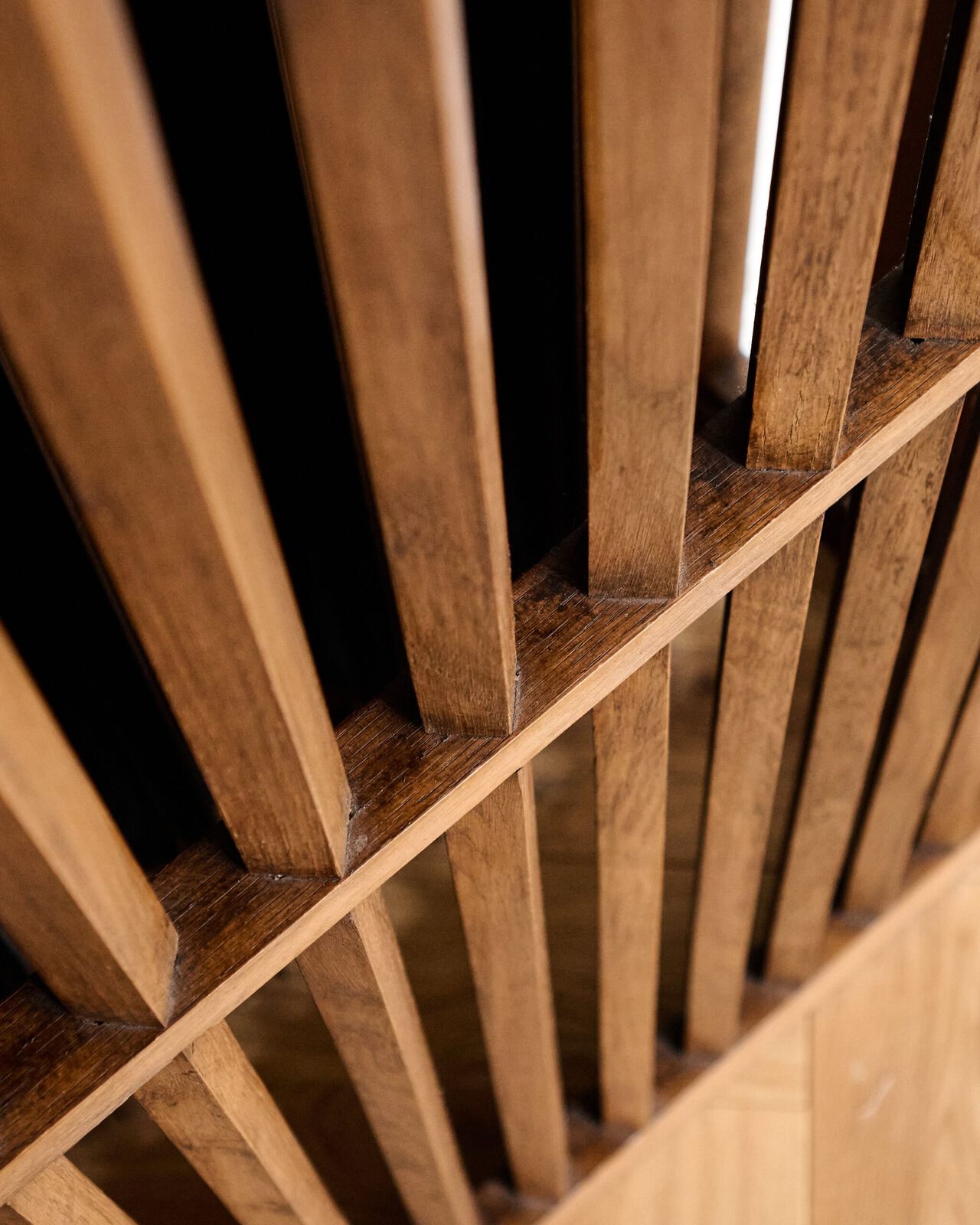 Detailaufnahme einer Holztreppe mit schr&auml;g verlaufenden Stufen und Gel&auml;nder aus hellem Holz.